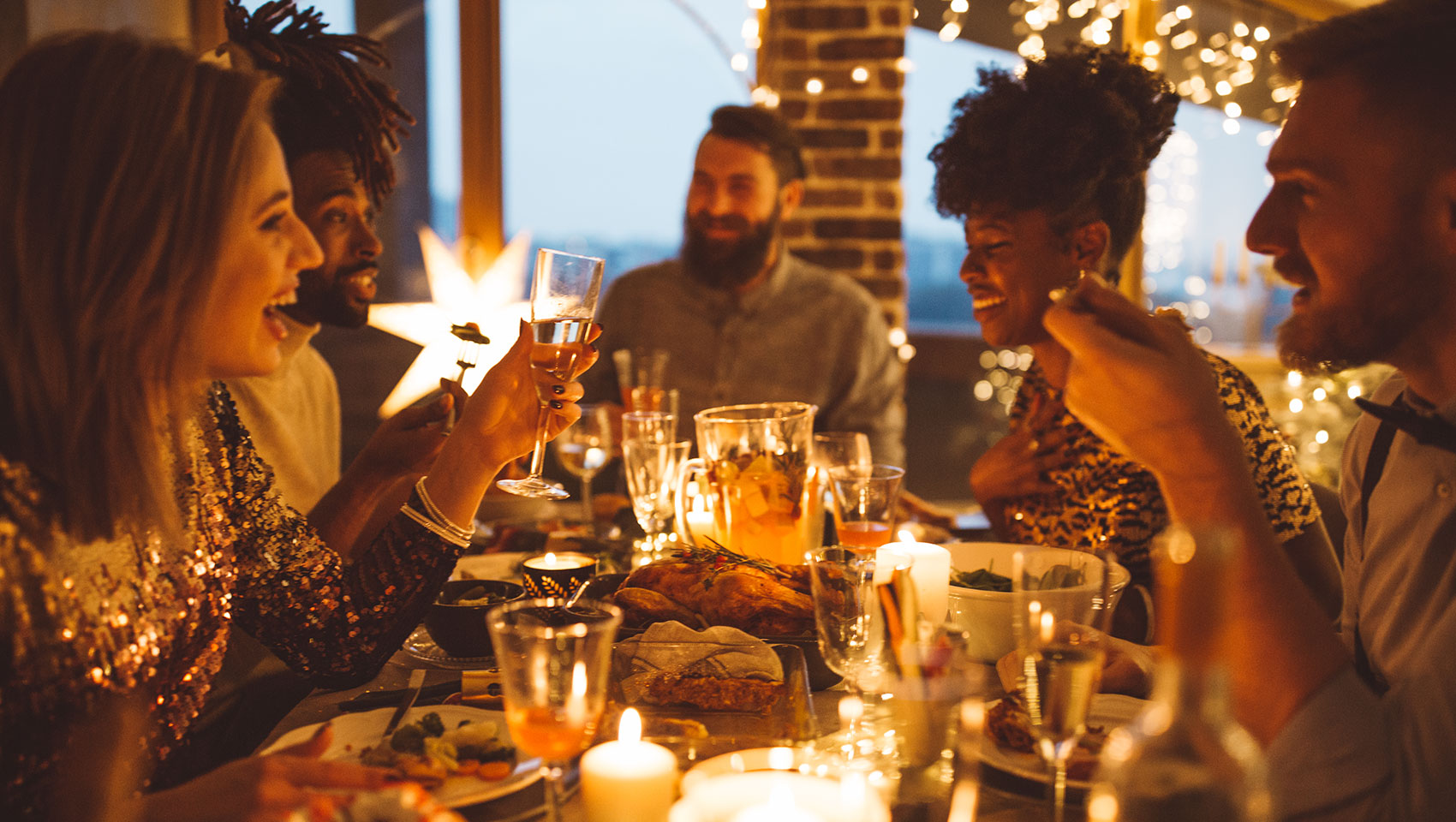 adults gathered around a table toasting at a holiday party