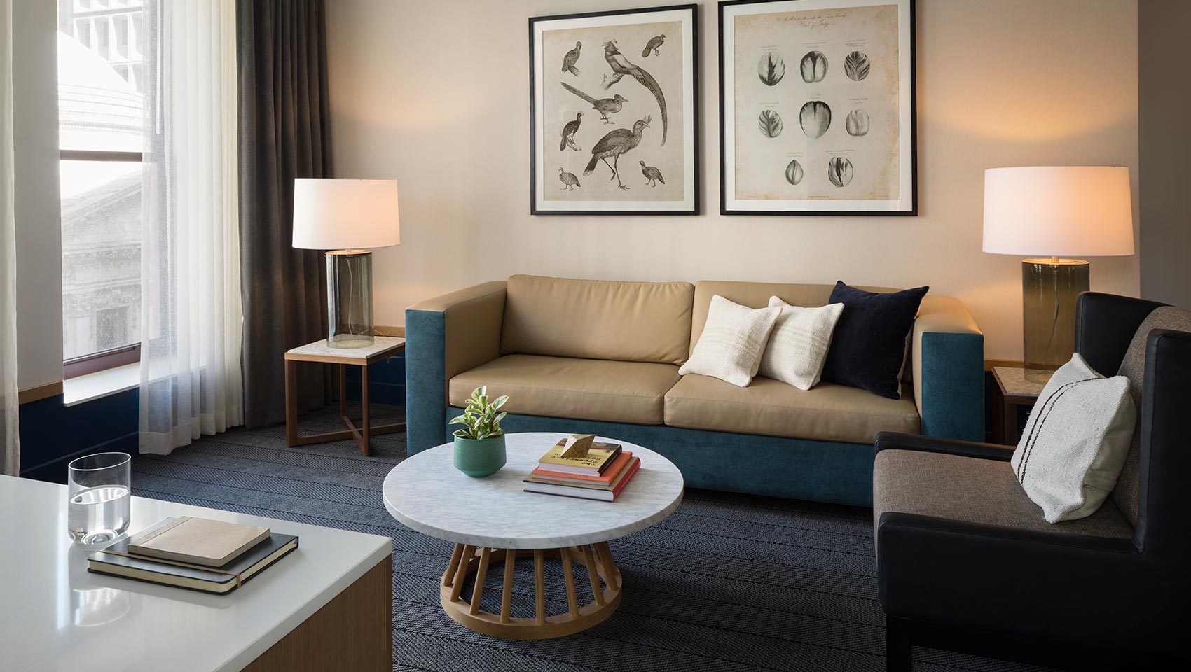 Suite living area with tan and blue couch, chair, and table at Kimpton Schofield Hotel